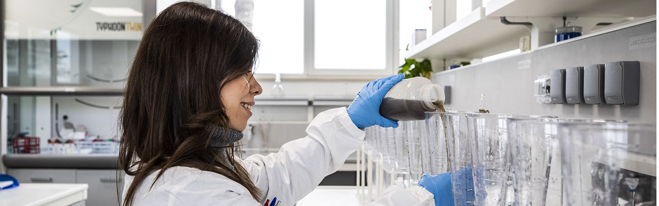 Una donna con camice bianco conduce delle analisi di laboratorio