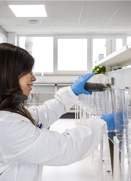 Una donna con camice bianco conduce delle analisi di laboratorio