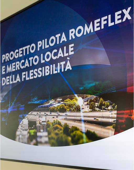 Dettaglio di un pannello informativo con il testo "Romeflex e mercato locale della flessibilità". La grafica è moderna, con un'inserzione autostradale come sfondo.