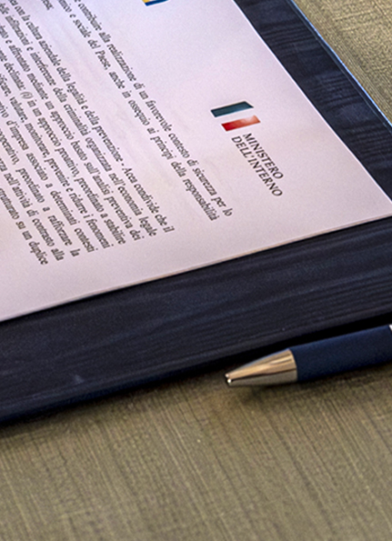 Persona che sfoglia un documento ufficiale del Ministero dell'Interno italiano appoggiato su un tavolo