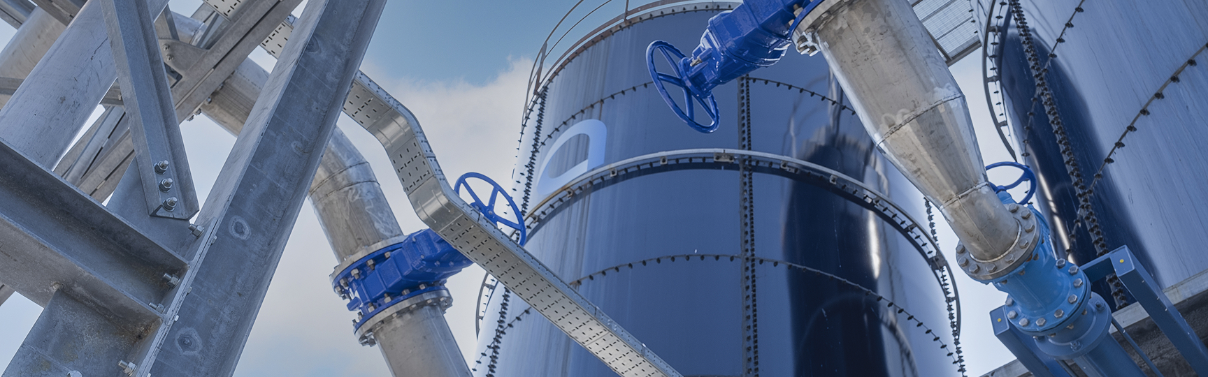 un impianto industriale con un grande serbatoio cilindrico blu