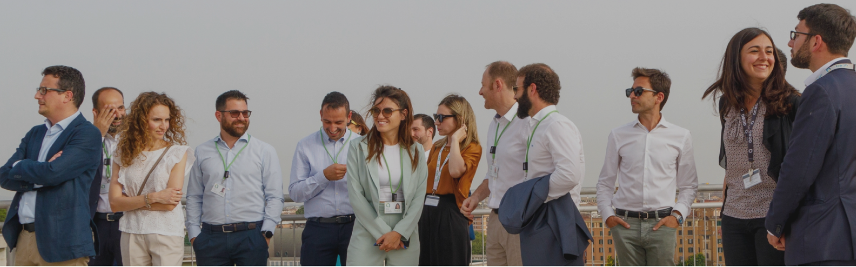 gruppo di persone in posa per una foto panoramica, in terrazzo esterno con vista su Roma