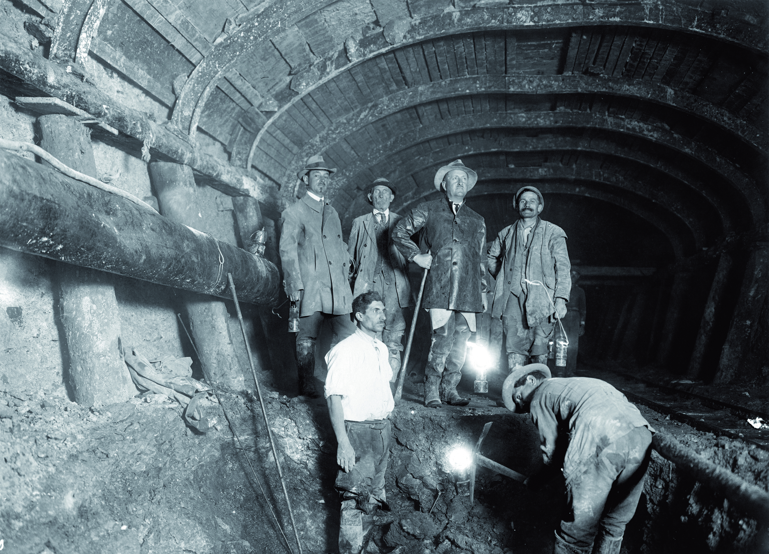 black and white photos of workers working in a tunnel