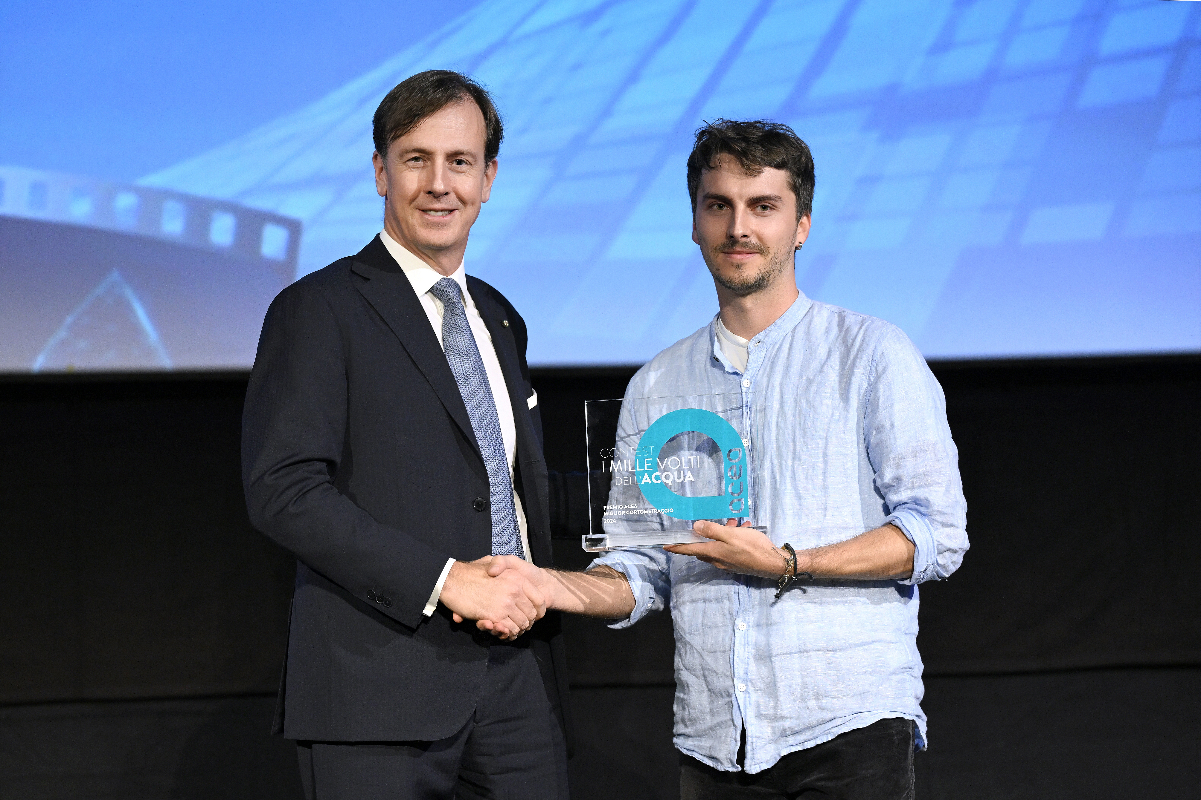 l'Amministratore Delegato Fabrizio Palermo stringe la mano ad uno dei vincitori del contest i mille volti dell'acqua