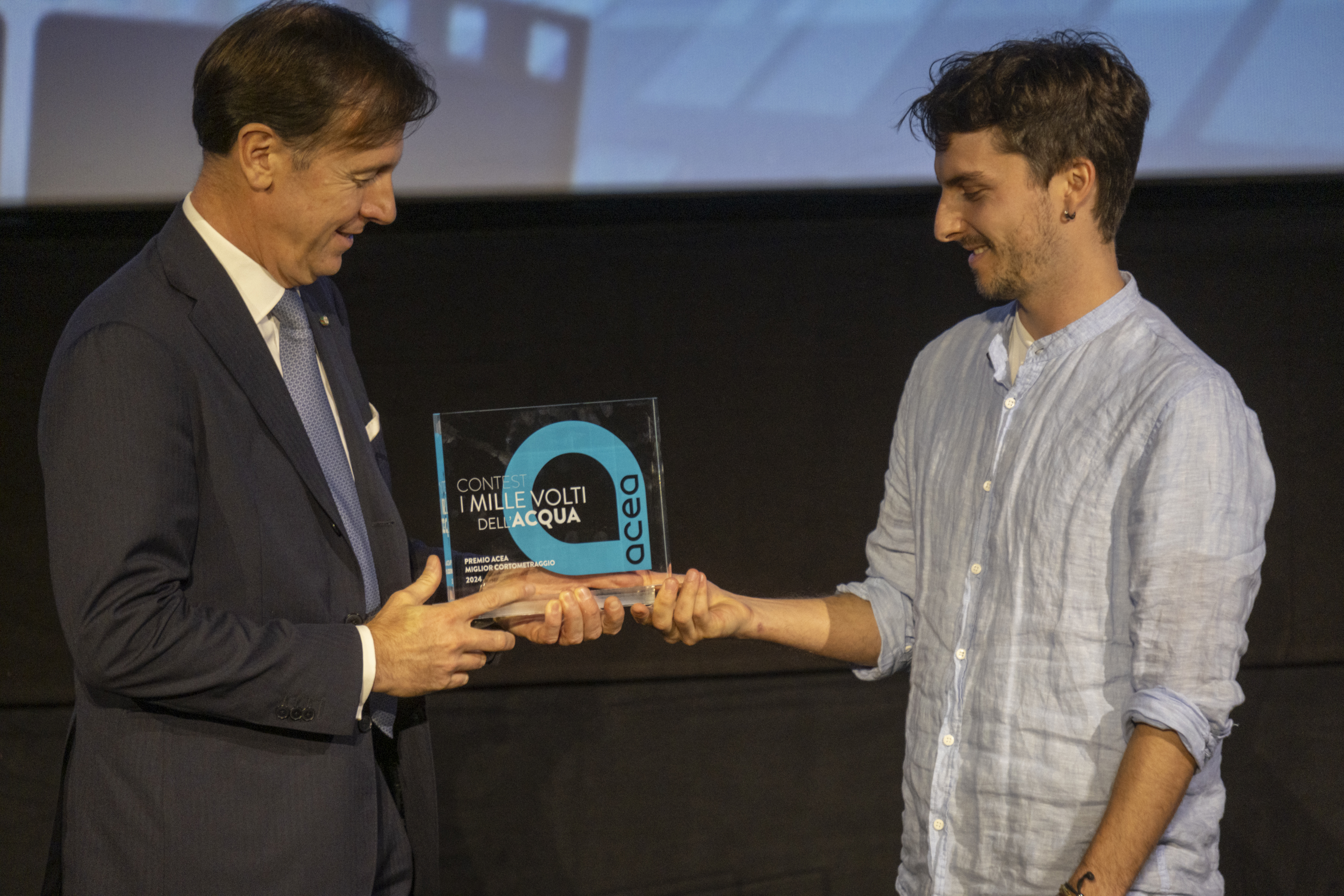 l'Amministratore Delegato Fabrizio Palermo consegna il premio ad uno dei vincitori del contest i mille volti dell'acqua