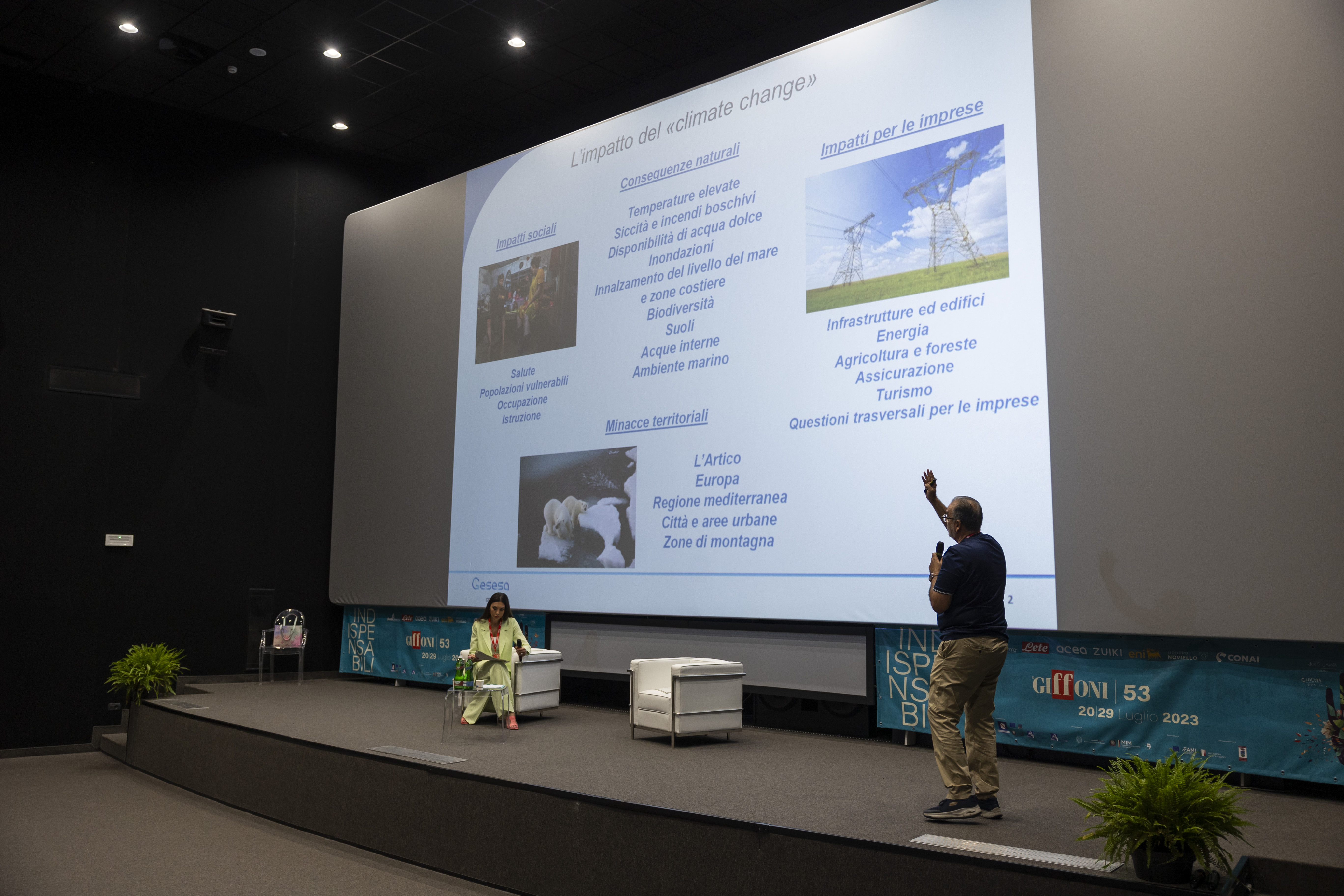 an acea employee giving a speech on climate change while pointing to a projected slide