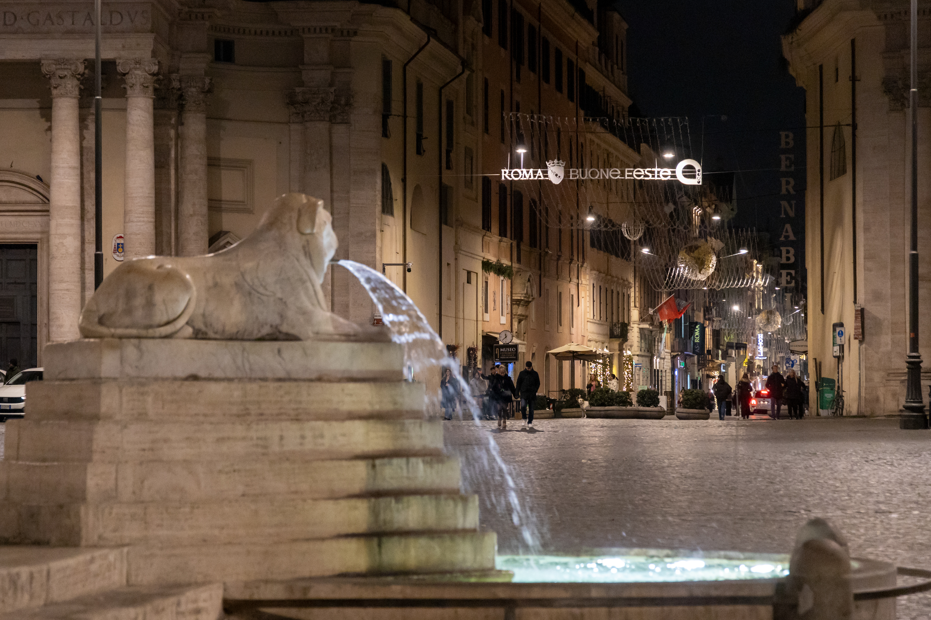 fontana di piazza del popolo con l'inizio di via del corso illuminato