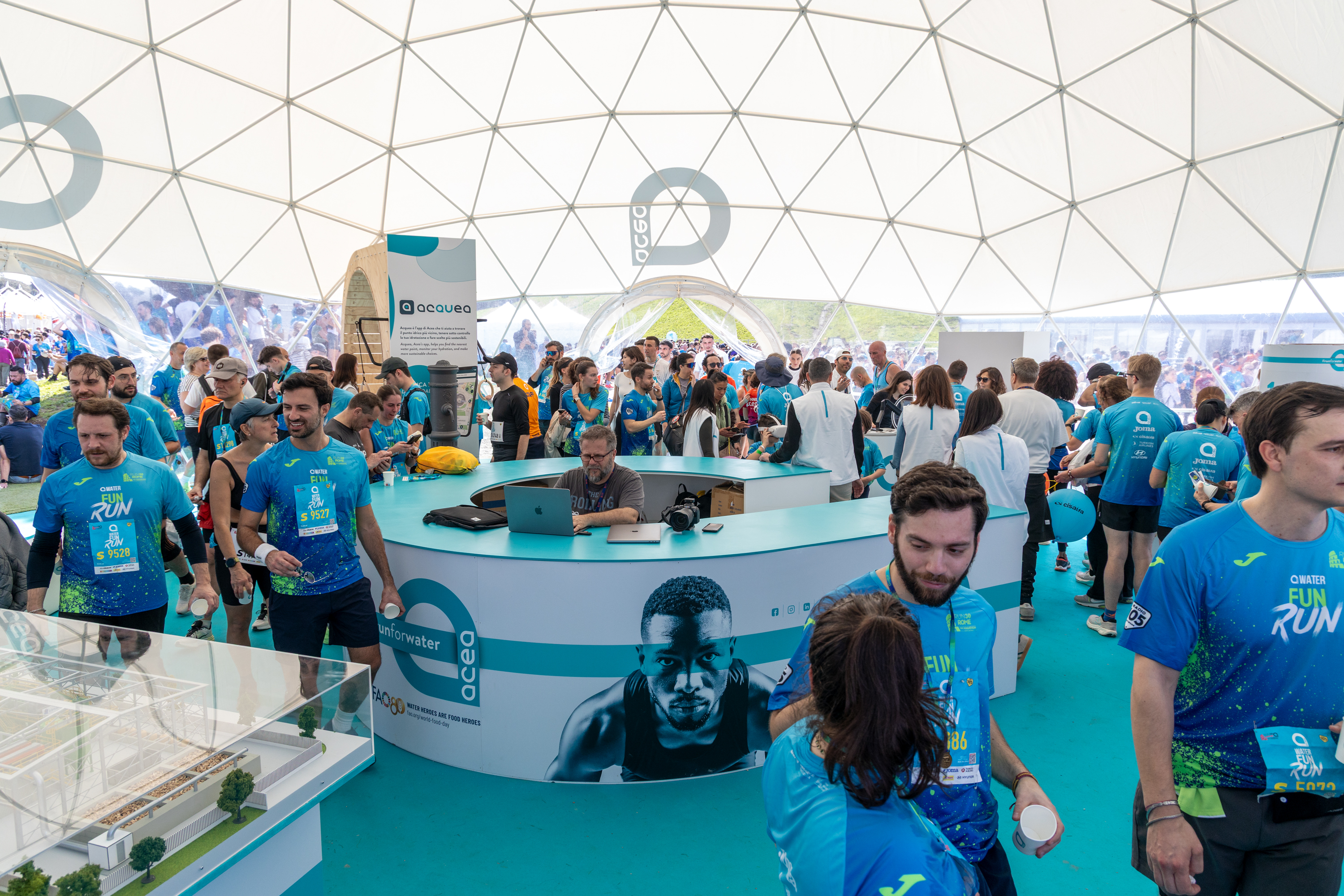Marathon participants gathered under a marquee before the start of the event