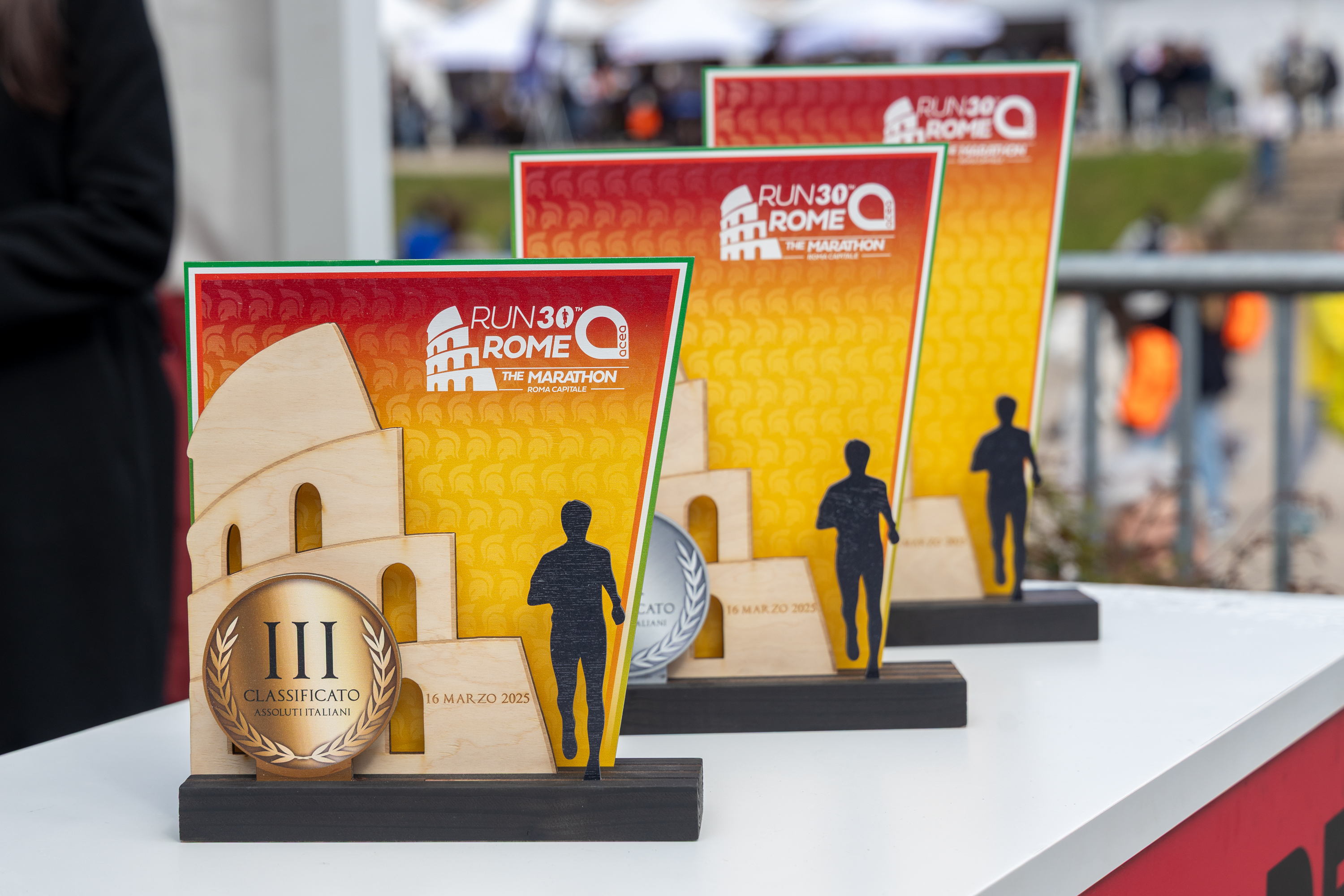 the prizes for first, second and third place photographed one after the other. in the foreground is third place