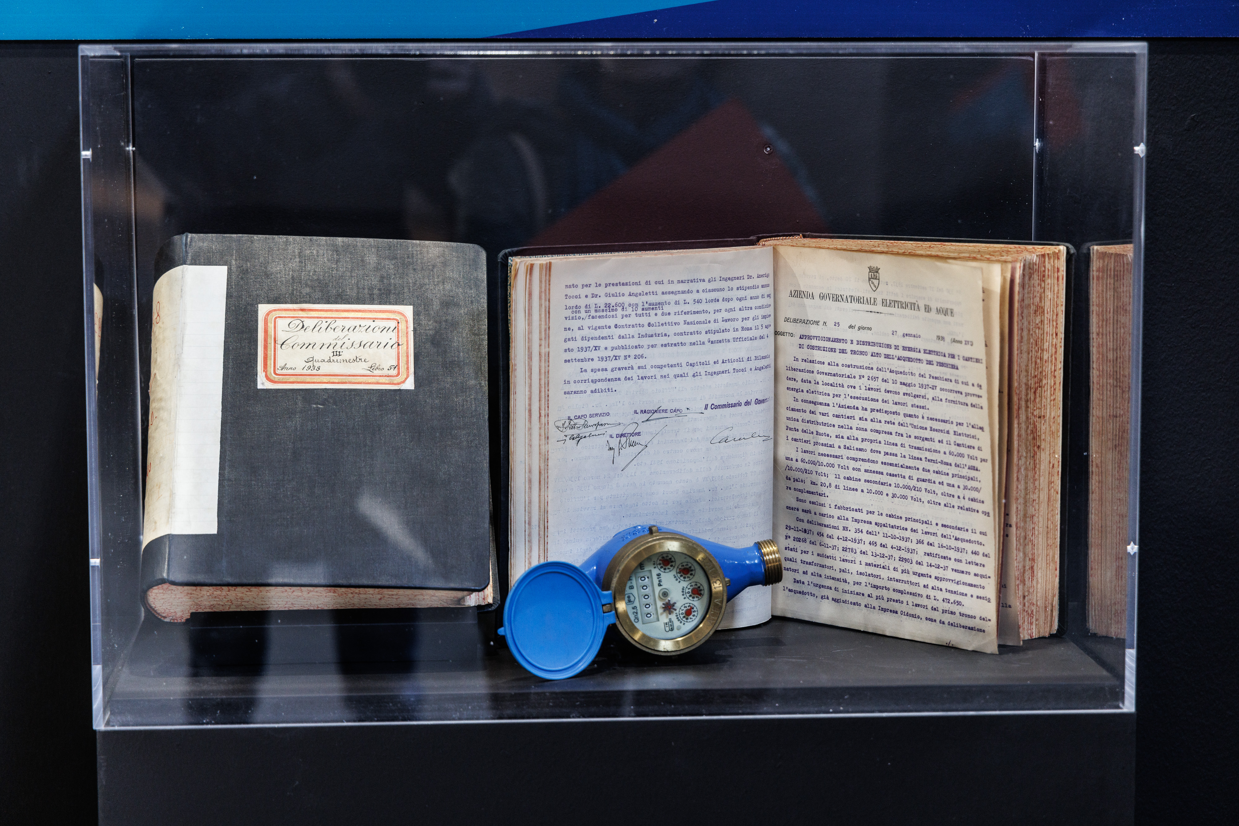 a display case containing an archaeological find and two ancient books
