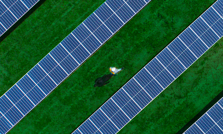 Un uomo cammina in un parco fotovoltaico