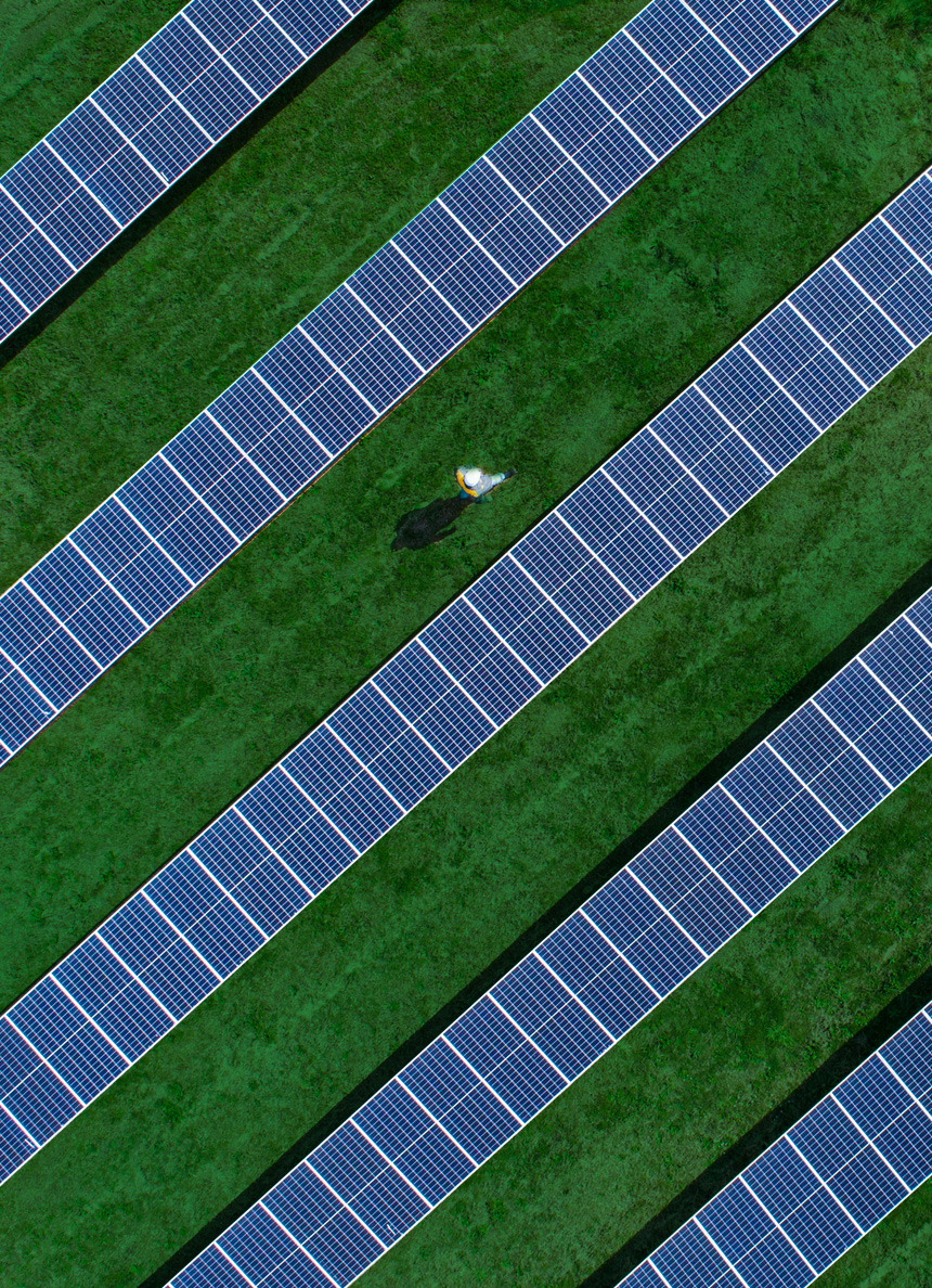 Un uomo cammina in un parco fotovoltaico